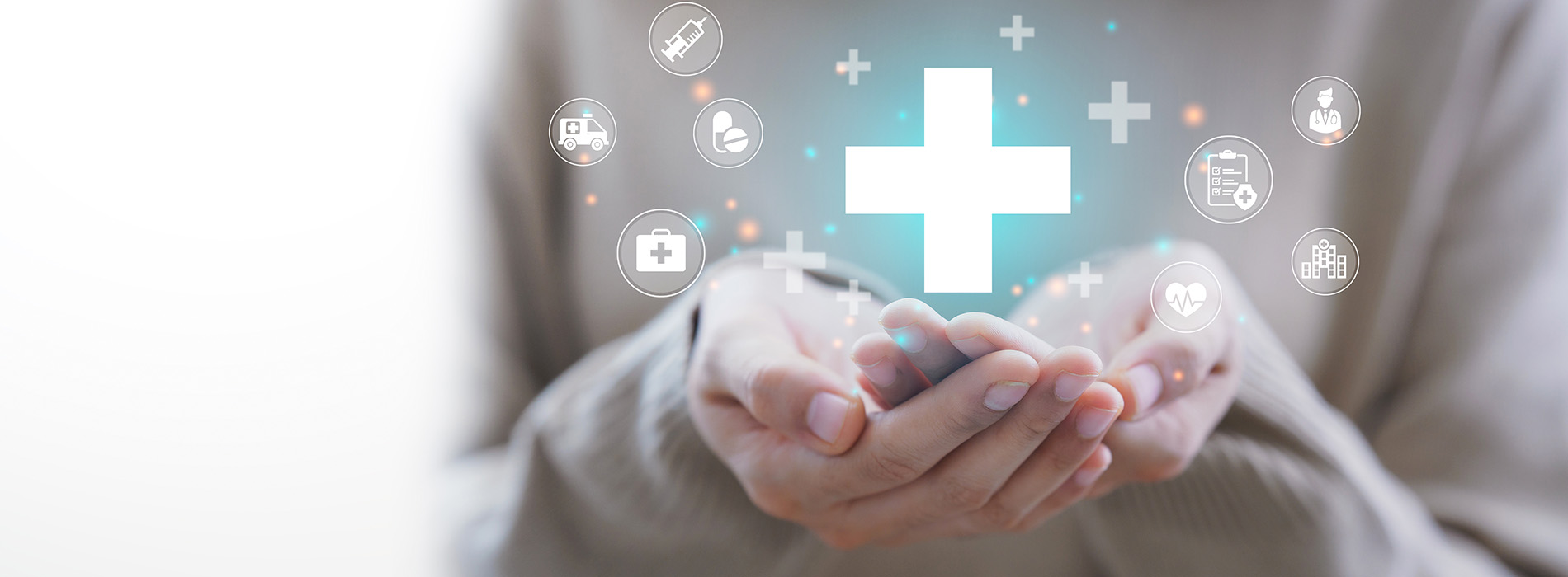 The image depicts a human hand holding a glowing blue cross with various digital icons surrounding it, symbolizing healthcare and technology.