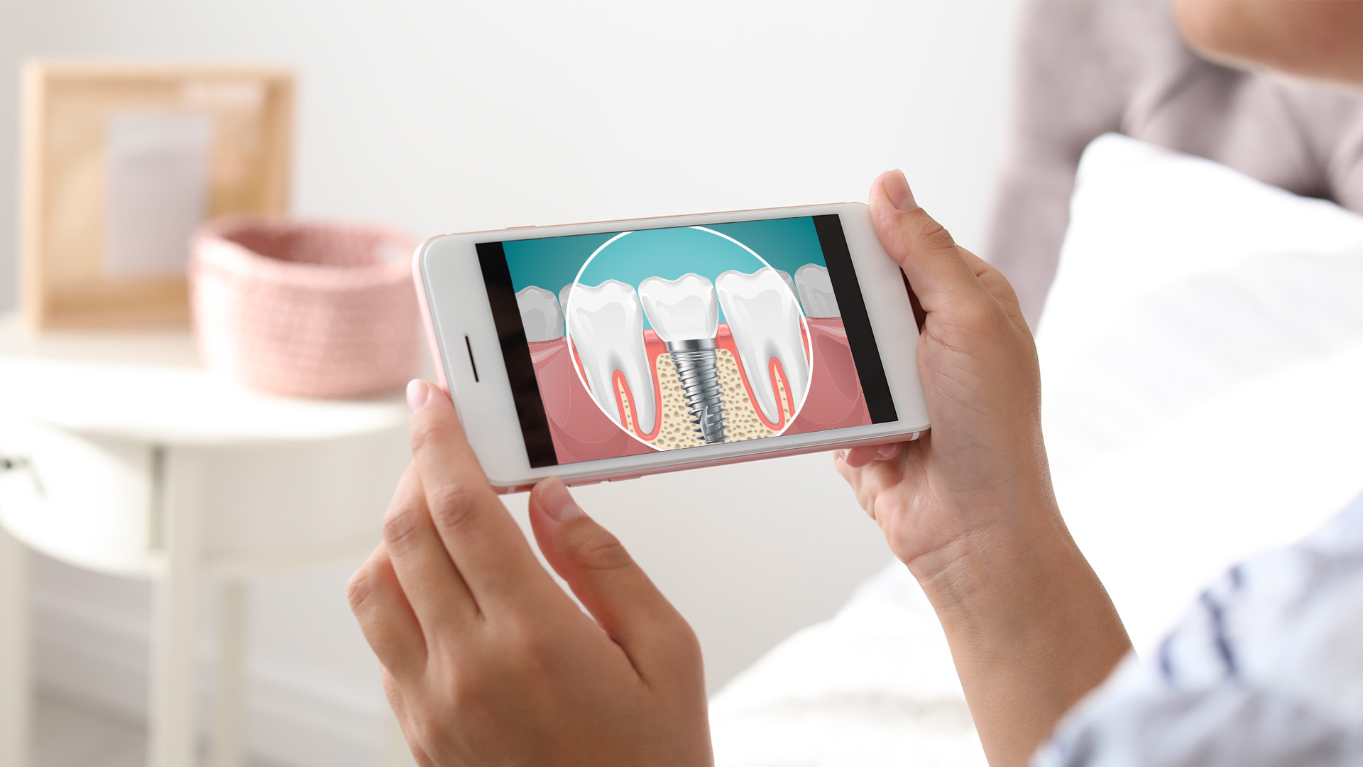 A person holding a smartphone displaying an image of a tooth with a gum disease treatment, suggesting oral health or dental care advice.