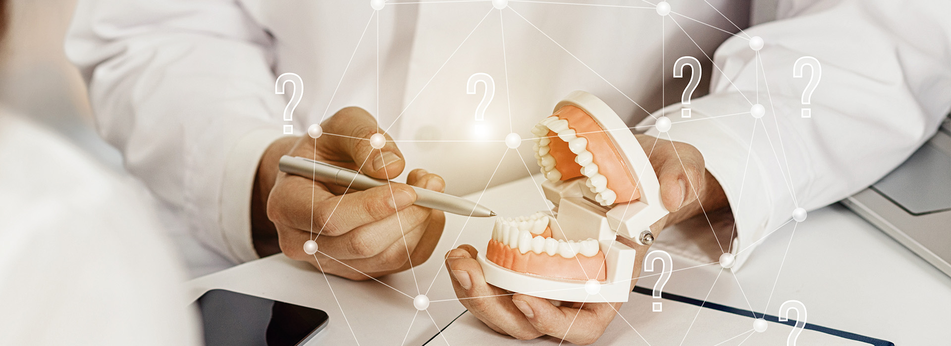 The image shows a person holding a dental model, possibly in a dental office or educational setting, with various numbers and annotations indicating different aspects of the model.