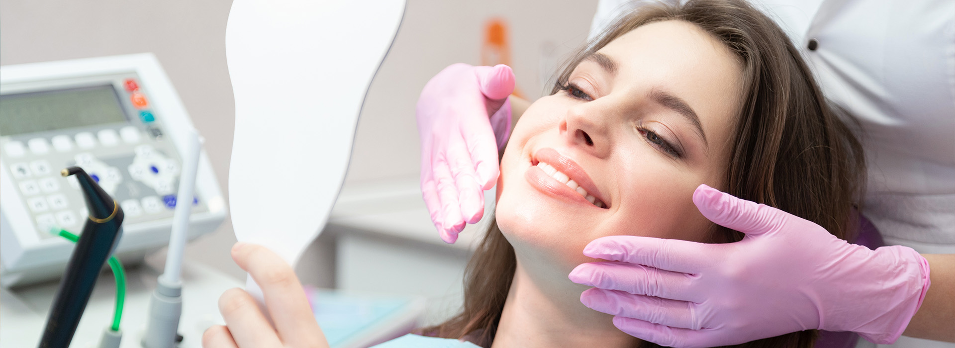 The image shows a person sitting in a dental chair with their eyes closed, receiving dental care.