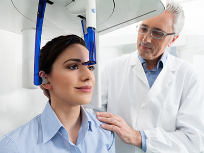 A medical professional is showing a woman a 3D model of her head, likely for a dental or orthodontic consultation.