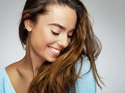 A woman with long hair, smiling softly at the camera.